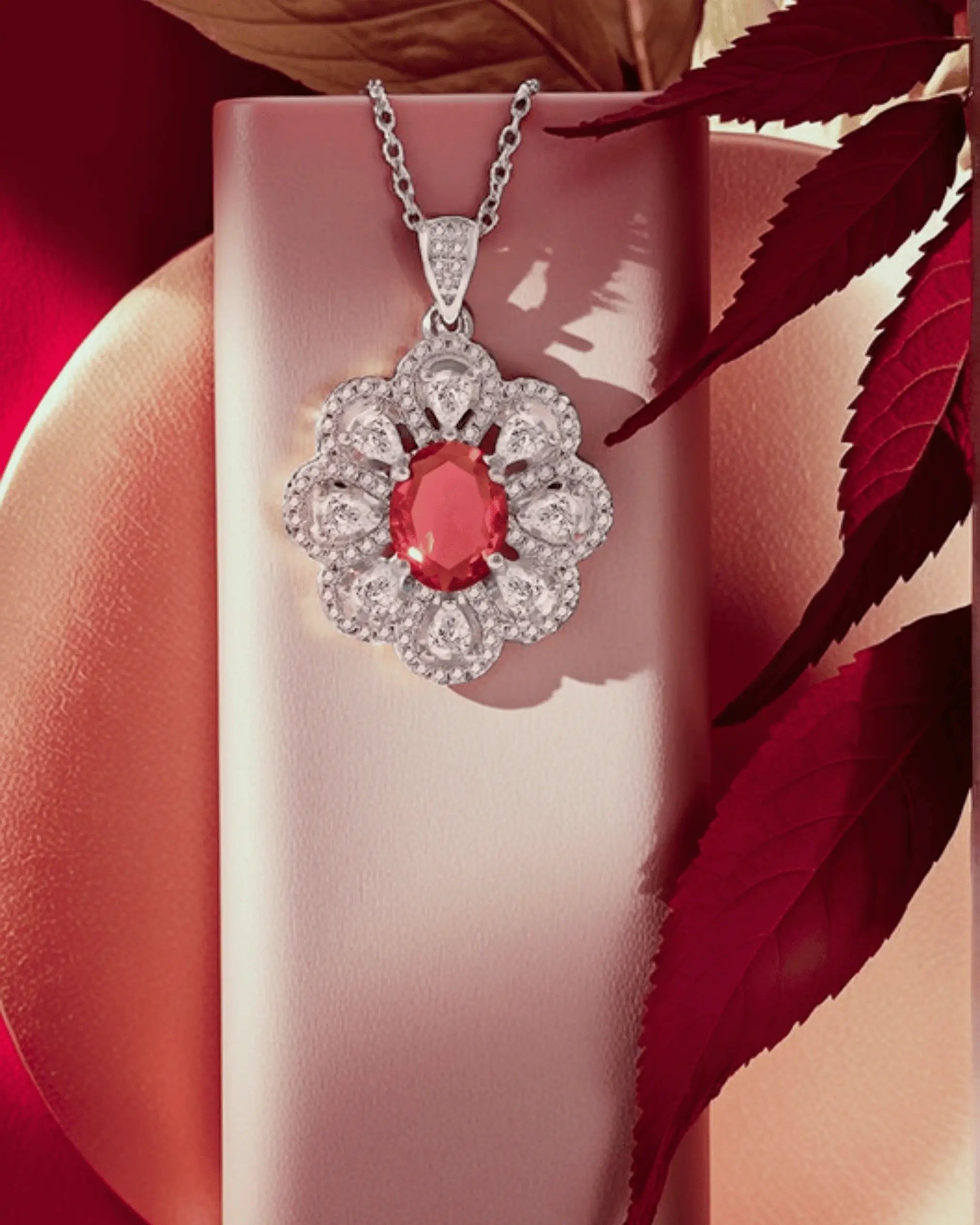 Full jewelry set including a matching necklace, ring, and dangle earrings, all in a silver flower cluster design with bright red/pink oval gemstones.