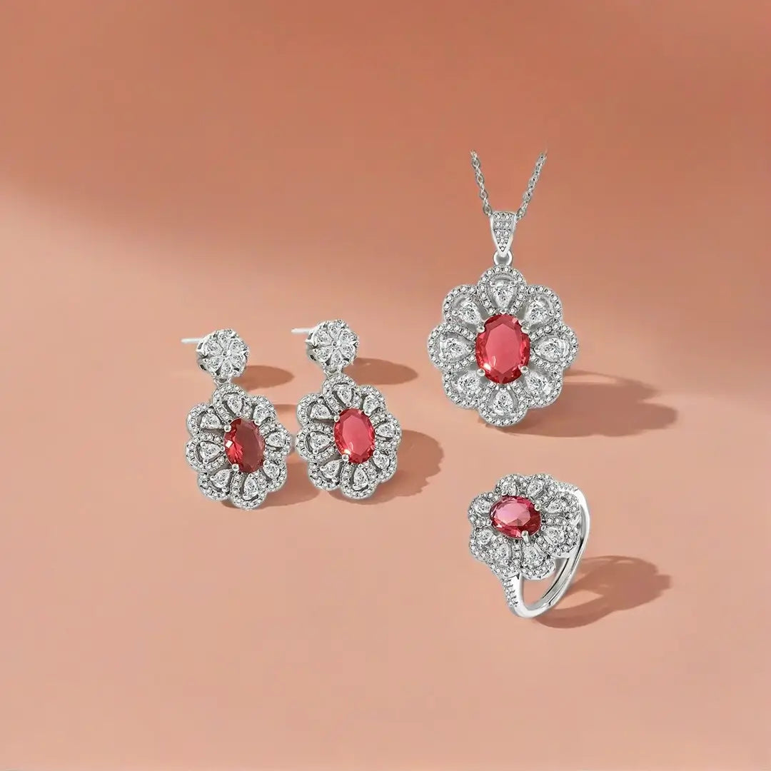 Silver chain necklace with a large pendant in a floral cluster style, featuring an oval red-pink gemstone surrounded by white teardrop and pave crystals.