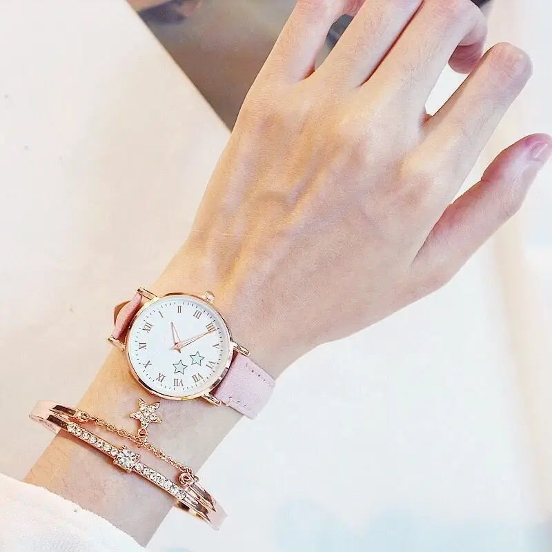 Alt Text: Rose gold minimalist wristwatch with a light pink leather strap, paired with a matching star charm chain bracelet.