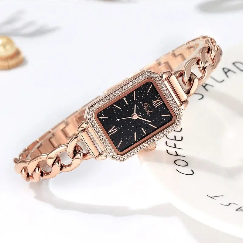 Elegant rose gold chain watch with a rectangular case, rhinestone frame, and a deep black starlight or galaxy dial for a luxury look.