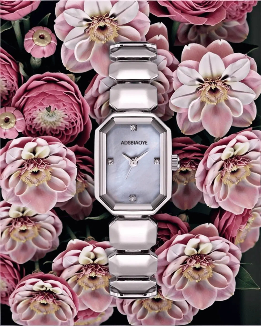 Silver link bracelet watch with an octagonal case, mother-of-pearl dial, and diamond hour markers, centered against a vibrant background of pink flowers.