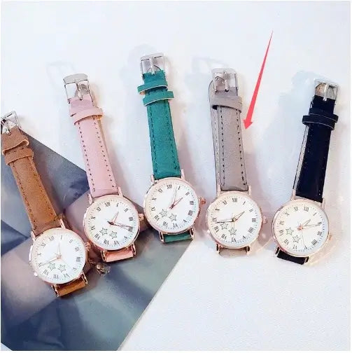 Group shot of five women's minimalist watches with rose gold casings and interchangeable straps in pink, green, gray, black, and tan leather.